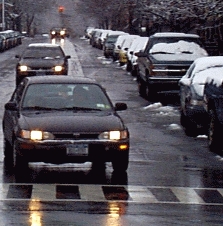 cars travelling a roadway during winter weather conditions